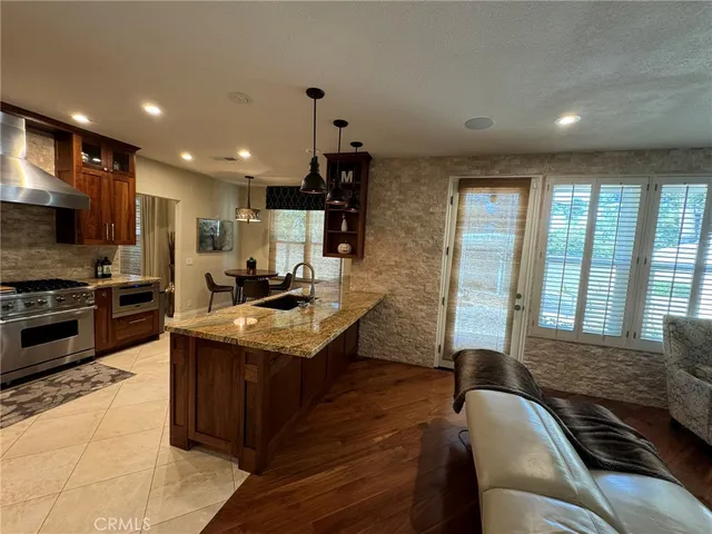 a kitchen with stainless steel appliances granite countertop a refrigerator a stove a sink and a oven