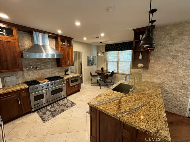 a kitchen with stainless steel appliances granite countertop a stove and a sink