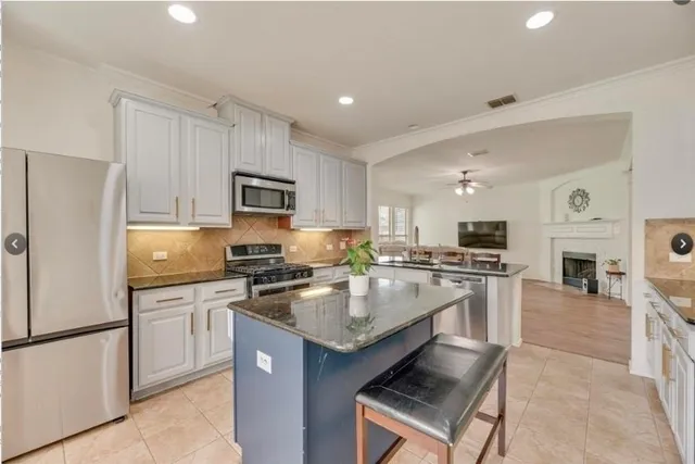 a kitchen with stainless steel appliances granite countertop a refrigerator stove microwave and sink