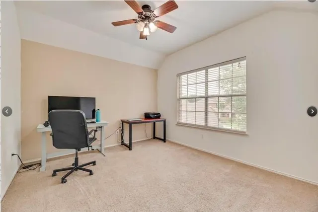 a view of a workspace with furniture and a window
