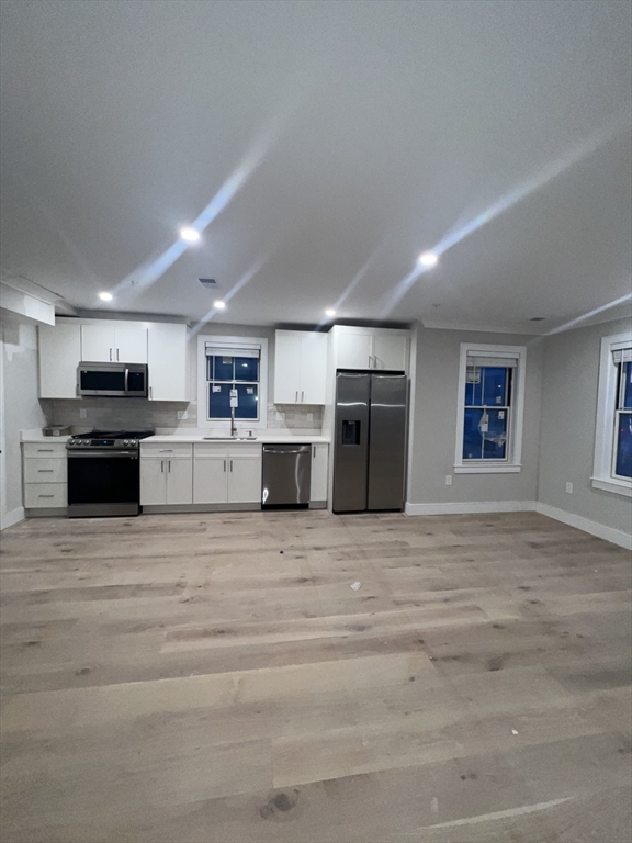 a large kitchen with stainless steel appliances kitchen island a large counter top and oven