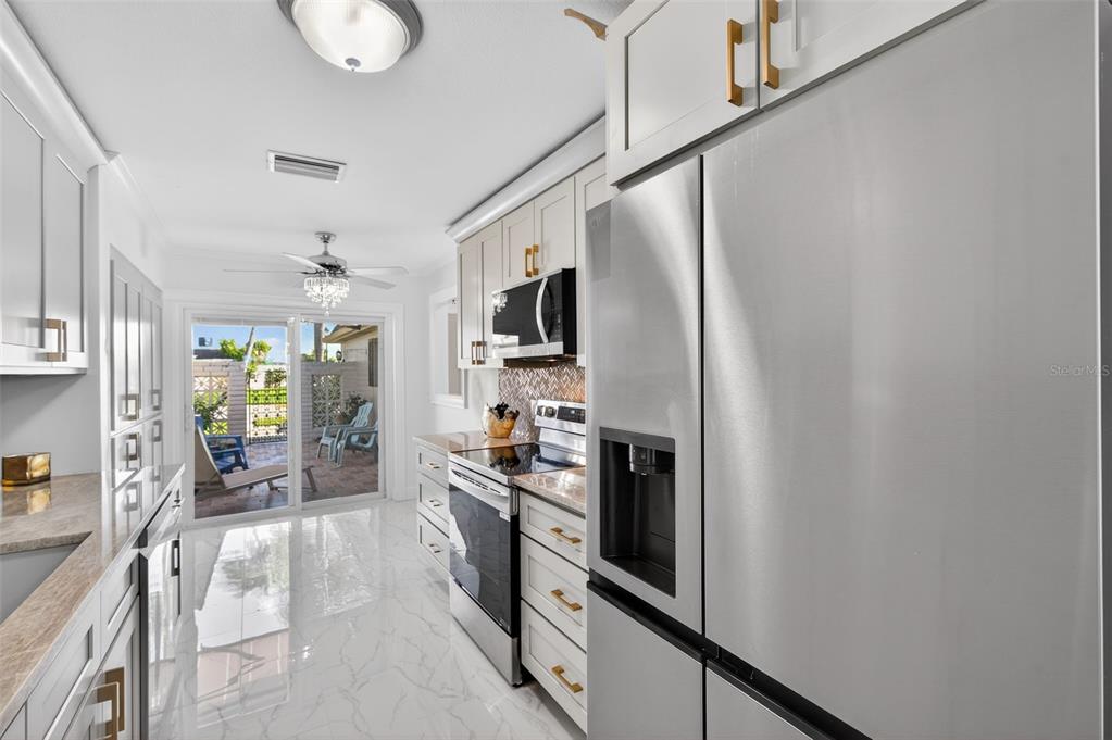 427 Boca Ciega Point Boulevard North St. Petersburg, FL 33708 - Photo 11 of 69 a kitchen with stainless steel appliances a refrigerator and a stove