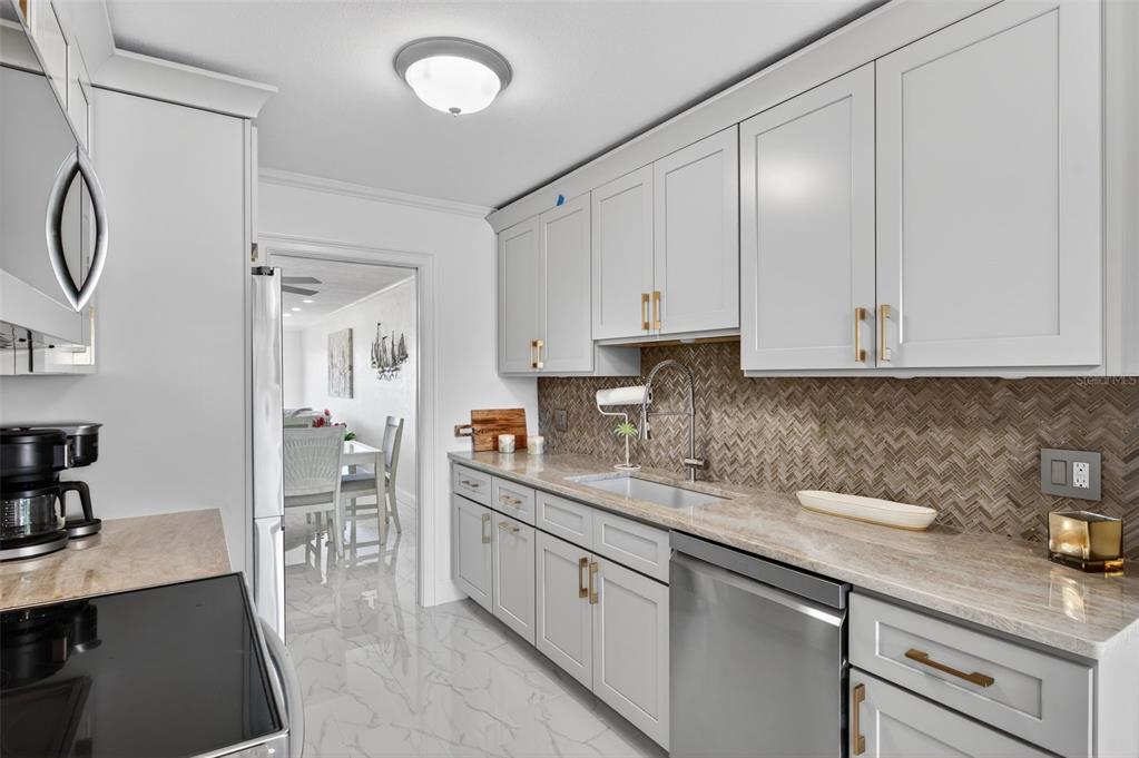 427 Boca Ciega Point Boulevard North St. Petersburg, FL 33708 - Photo 16 of 69 a kitchen with stainless steel appliances granite countertop a sink stove and cabinets