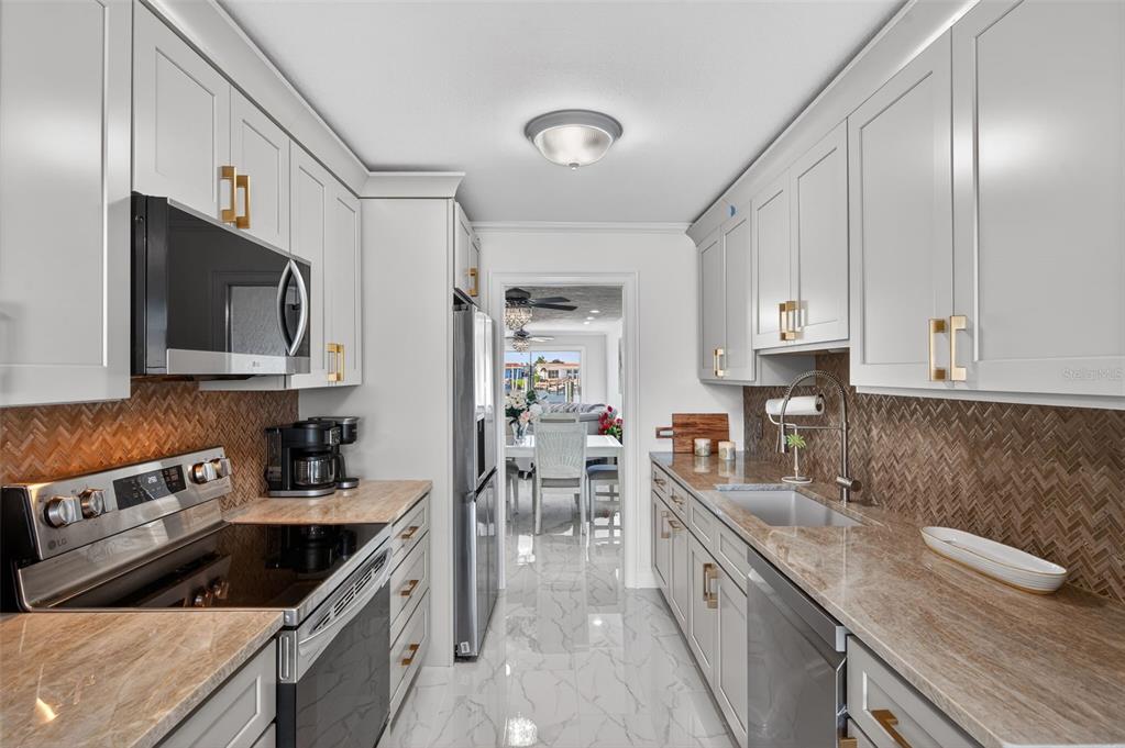 427 Boca Ciega Point Boulevard North St. Petersburg, FL 33708 - Photo 17 of 69 a kitchen with a sink stove and microwave