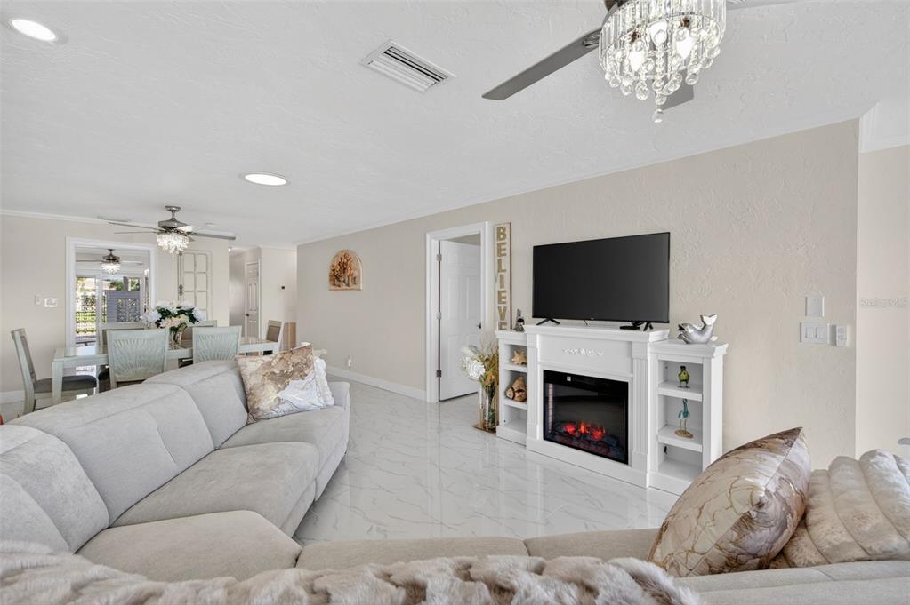 427 Boca Ciega Point Boulevard North St. Petersburg, FL 33708 - Photo 25 of 69 a living room with furniture a flat screen tv and a fireplace