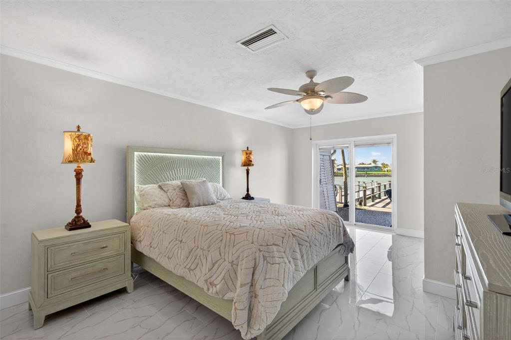 427 Boca Ciega Point Boulevard North St. Petersburg, FL 33708 - Photo 26 of 69 a bedroom with a bed chandelier and a window
