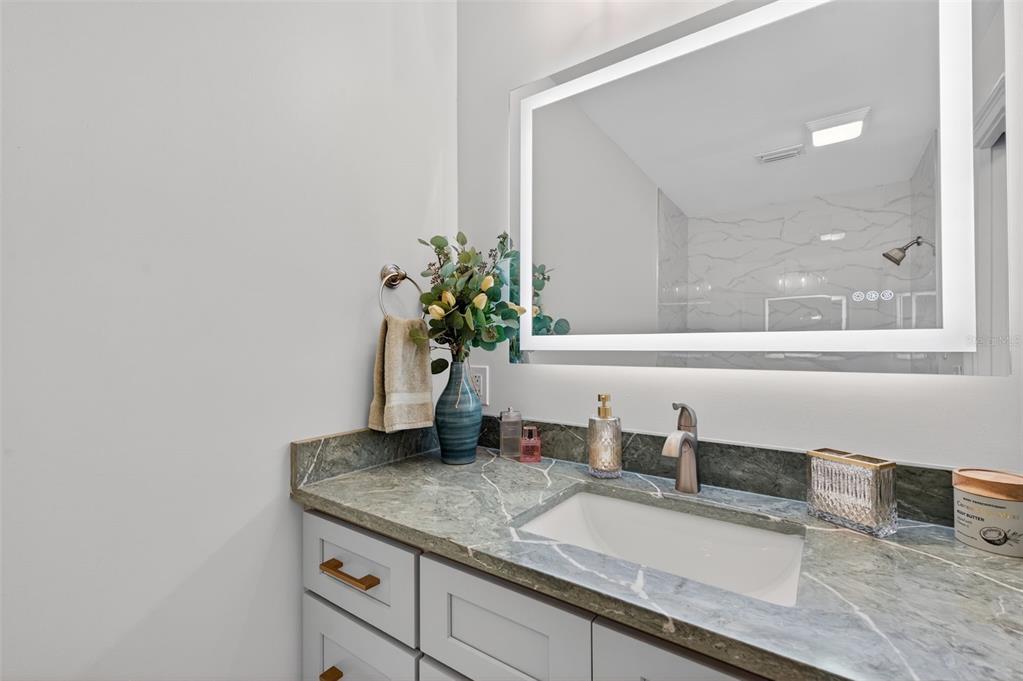 427 Boca Ciega Point Boulevard North St. Petersburg, FL 33708 - Photo 32 of 69 a bathroom with a granite countertop sink and a mirror
