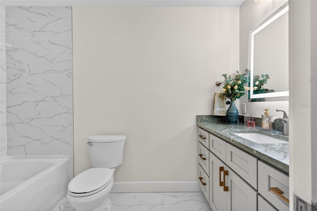 427 Boca Ciega Point Boulevard North St. Petersburg, FL 33708 - Photo 33 of 69 a bathroom with a granite countertop toilet a sink and a bathtub