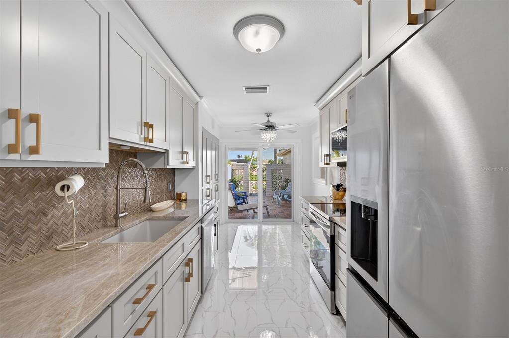 427 Boca Ciega Point Boulevard North St. Petersburg, FL 33708 - Photo 10 of 69 a kitchen with granite countertop a sink stove and cabinets