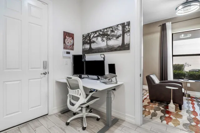 a view of a workspace with furniture and a window