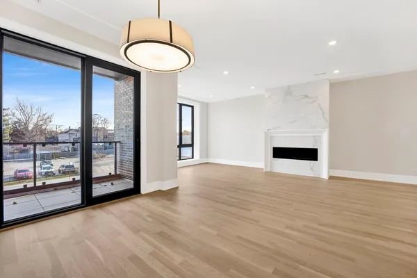 a view of empty room with wooden floor and fireplace