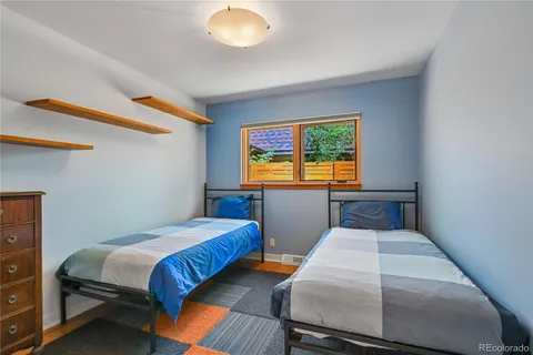 a bedroom with two beds and a potted plant