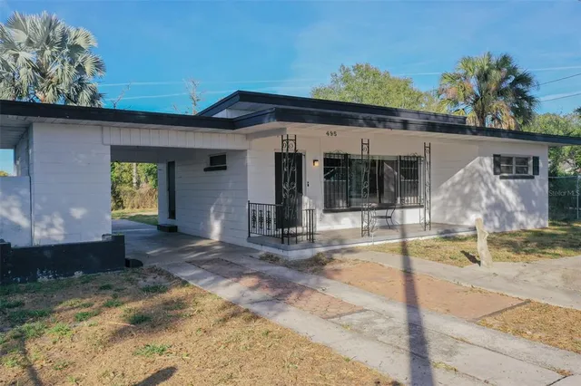 a view of a house with backyard and sitting area