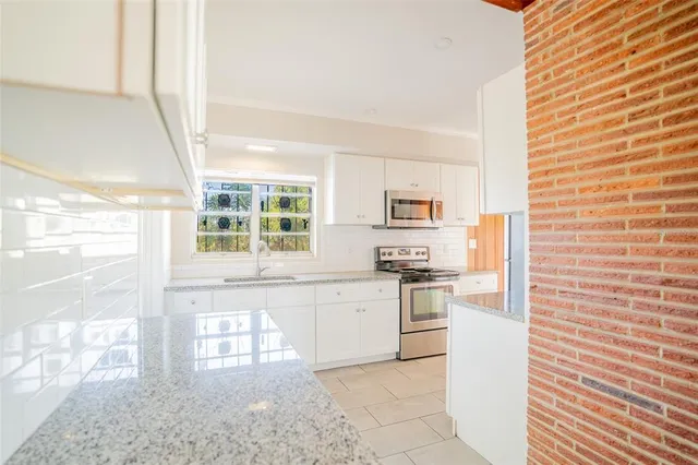 a kitchen with stainless steel appliances a stove top oven