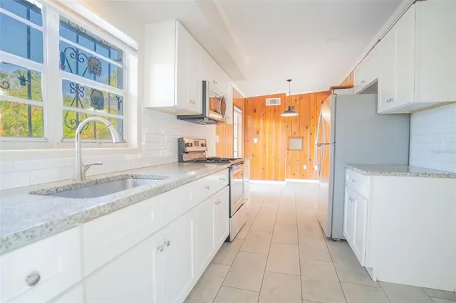 a bathroom with a granite countertop sink and a window