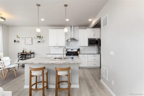 a kitchen with a dining table chairs refrigerator and cabinets