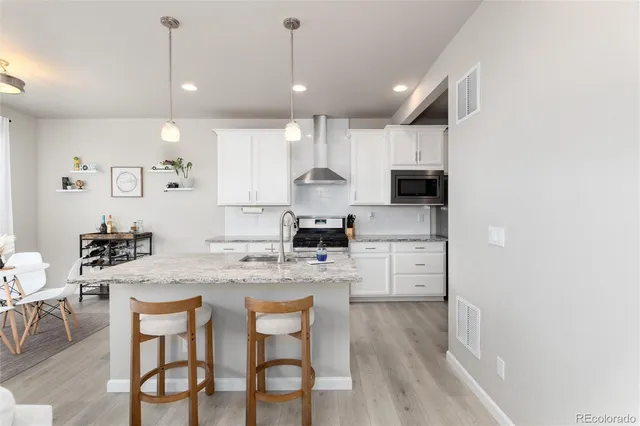 a kitchen with a dining table chairs refrigerator and cabinets