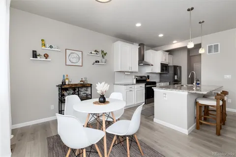 a kitchen with kitchen island a dining table and chairs