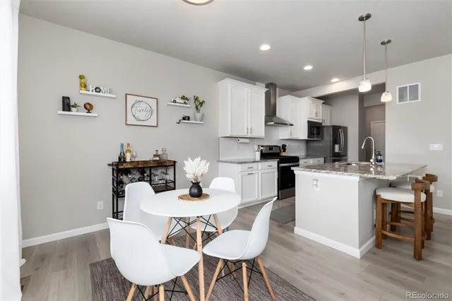 a kitchen with kitchen island a dining table and chairs