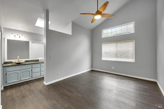 a view of an empty room with window and wooden floor