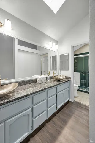 a bathroom with a granite countertop sink and a mirror