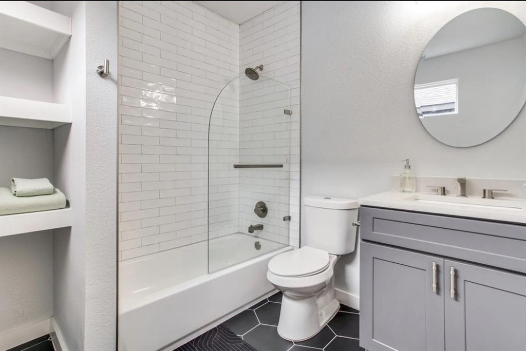 1606 West 12th Street Dallas, TX 75208 - Photo 11 of 20 Bathroom featuring shower / tub combination, vanity, a textured wall, and dark tile patterned floors