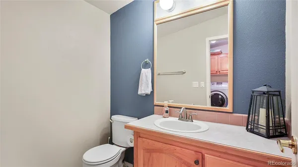 a bathroom with a toilet a sink and mirror