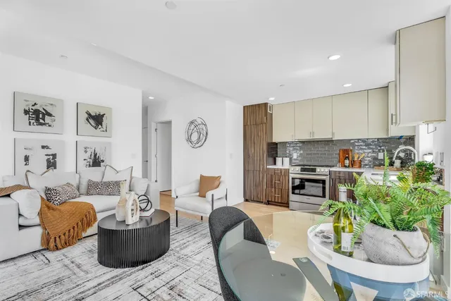 a living room with furniture and a dining table with chairs