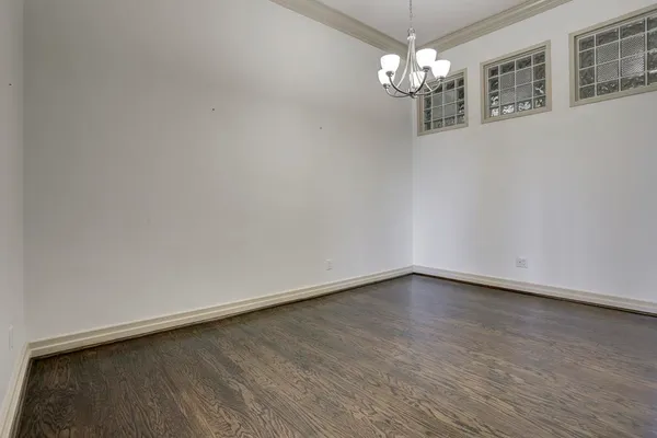 a view of a chandelier in big room with wooden floor
