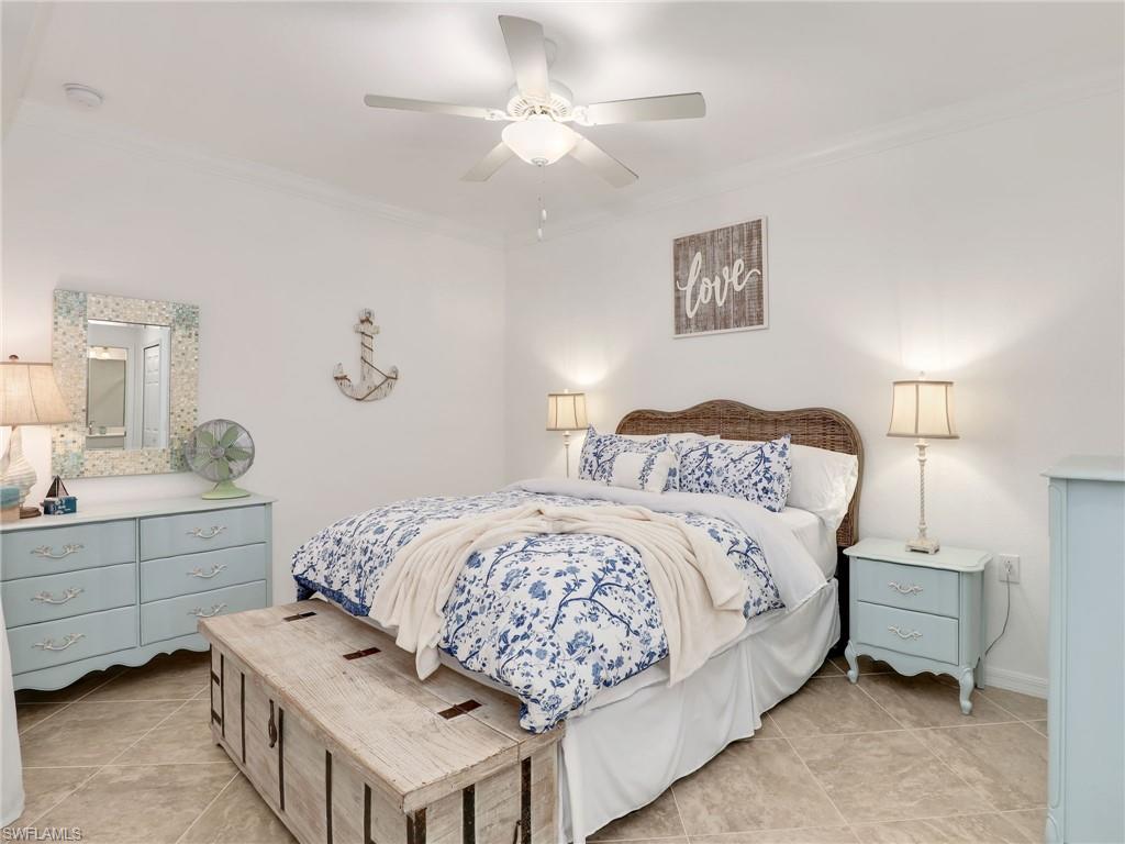 9584 Trevi Court, Unit 5213 Naples, FL 34113 - Photo 17 of 50 a bedroom with a bed and a table