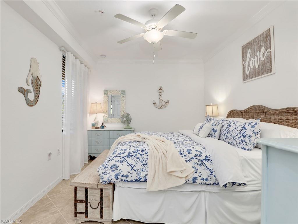 9584 Trevi Court, Unit 5213 Naples, FL 34113 - Photo 18 of 50 a bedroom with a bed and a chandelier