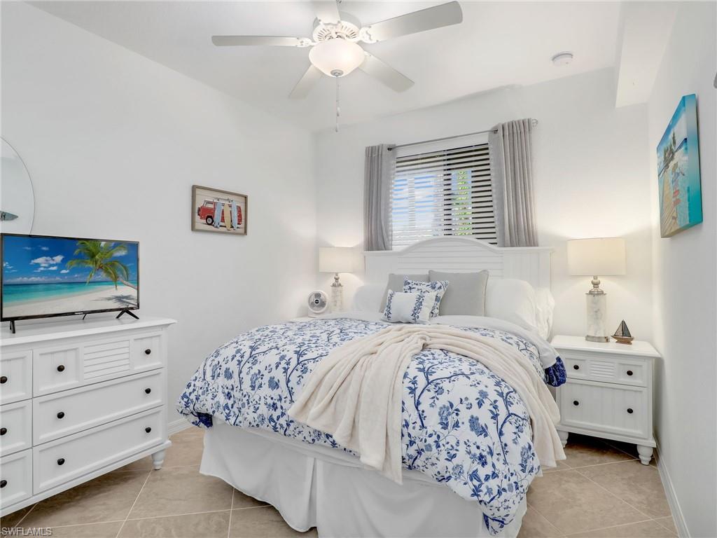 9584 Trevi Court, Unit 5213 Naples, FL 34113 - Photo 22 of 50 a bedroom with a bed and a flat screen tv
