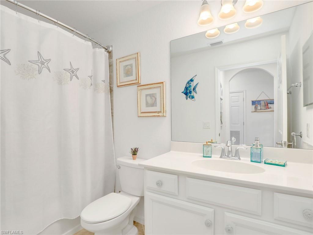 9584 Trevi Court, Unit 5213 Naples, FL 34113 - Photo 24 of 50 a bathroom with a sink a toilet a mirror a vanity and shower