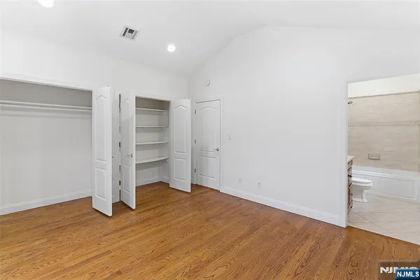 a bathroom with a bathtub shower sink vanity mirror and toilet