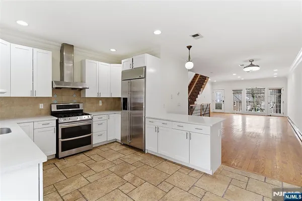 a kitchen with white cabinets and appliances