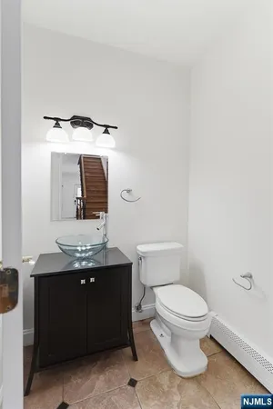 a bathroom with a granite countertop toilet sink and mirror