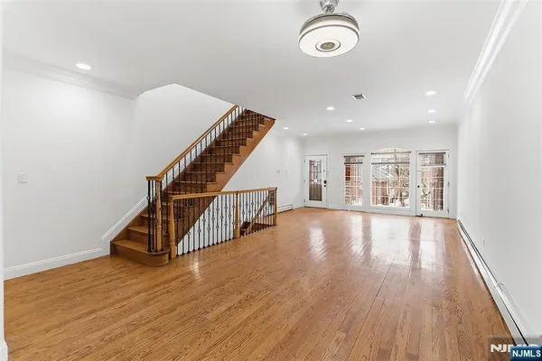 a view of a hallway with wooden floor and staircase