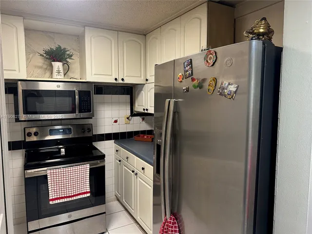 a kitchen with stainless steel appliances granite countertop a refrigerator and a stove