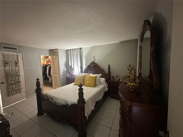 a bedroom with a bed and a potted plant