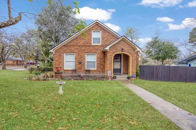 a front view of a house with yard and green space