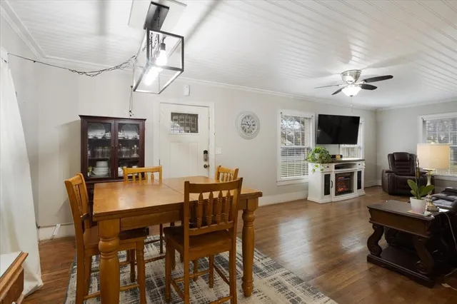 a kitchen with stainless steel appliances granite countertop a stove a sink dishwasher a refrigerator white cabinets and wooden floor