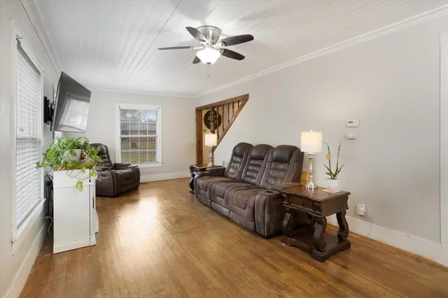 a living room with furniture and a flat screen tv with wooden floor