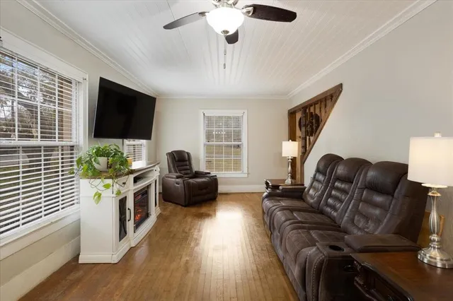 a living room with furniture a flat screen tv and a window
