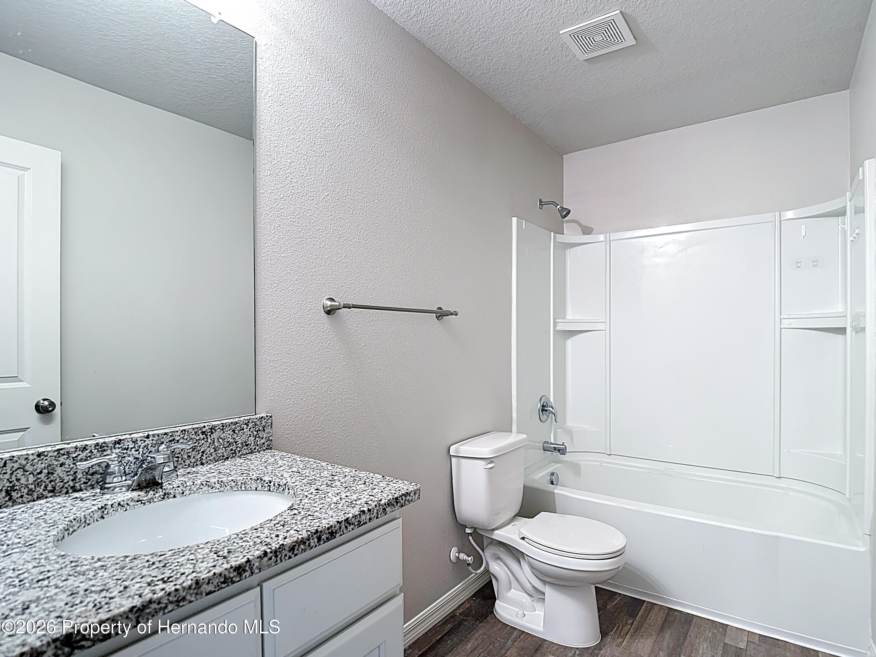 11374 Marcella Avenue Weeki Wachee, FL 34614 - Photo 54 of 70 a bathroom with a granite countertop sink toilet and shower