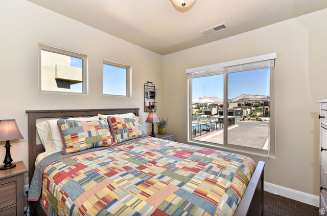 1622 Canyon Tree Drive St. George, UT 84770 - Photo 18 of 34 Bedroom featuring a large window with distant mountain scenery and a community pool