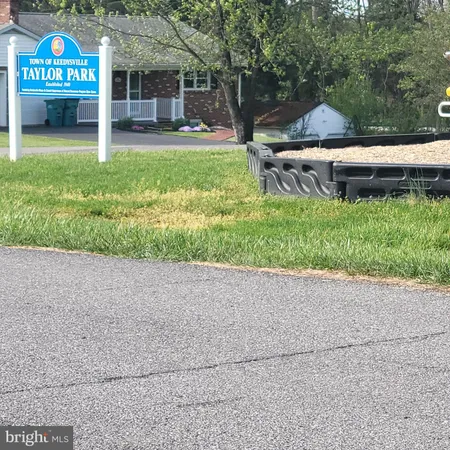 a view of a house with a yard and a bench