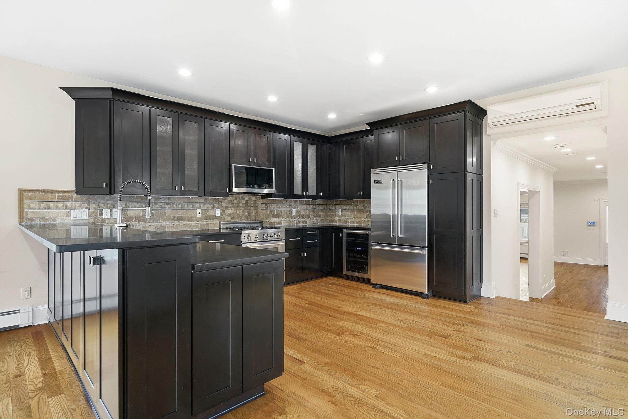 228 Central Avenue Rye, NY 10580 - Photo 9 of 24 a kitchen with kitchen island granite countertop wooden cabinets a refrigerator and a stove
