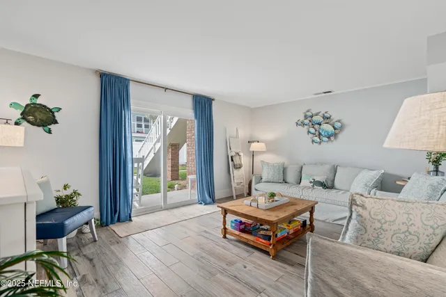 a living room with furniture a wooden floor and a large window