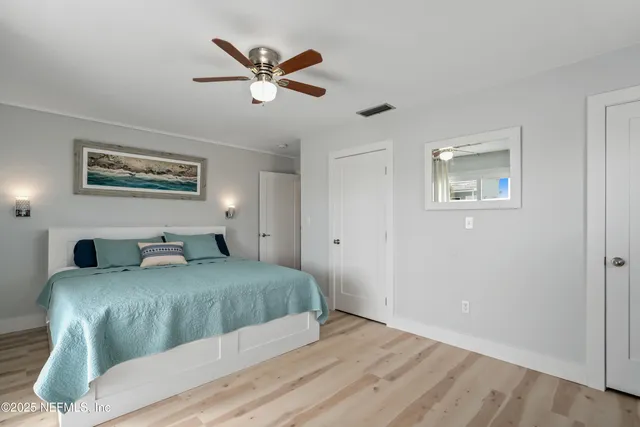 a bedroom with a large bed and a chandelier