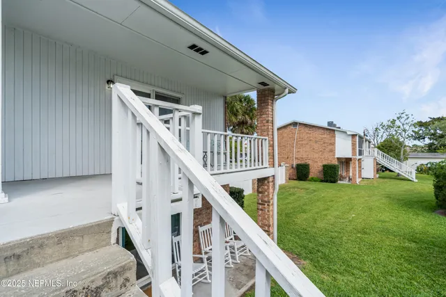 a view of house with yard and deck
